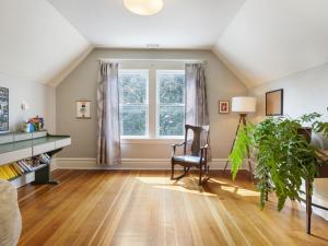 een woonkamer met een stoel en een raam bij Art Deco Oasis - Stylish 2BD with Den, Office, Garden and Dip Pool in Portland