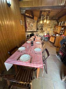 a long table with a red and white checkered table cloth at Bodega típica en El Molar sin camas ni dormitorios in El Molar