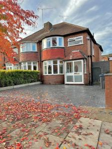 a brick house with a lot of leaves on the driveway at Luxurious family home in West Midlands in Northfield