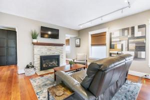 uma sala de estar com um sofá de couro e uma lareira em Dazzling 3bd, 2ba Home with Private Deck near Alberta em Portland