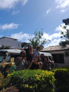 un grupo de personas de pie delante de una furgoneta en Vibe House Arraial en Arraial do Cabo