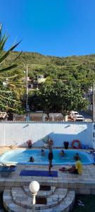 eine Gruppe von Personen in einem Schwimmbad in der Unterkunft Vibe House Arraial in Arraial do Cabo