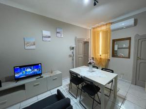 LA CASETTA DI LORENZO في لانشانو: غرفة معيشة مع تلفزيون وطاولة مع كراسي