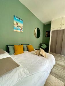 1 dormitorio con 1 cama blanca grande con almohadas amarillas en Le 25 / Hypercentre en Toulouse