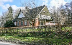 ein Backsteinhaus mit einem Zaun davor in der Unterkunft 3 Bedroom Beautiful Home In Tistrup in Tistrup
