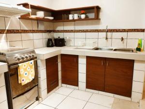 a kitchen with a stove and a sink at Apart Florencia 2 con cochera! in Tacna