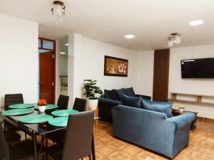 sala de estar con mesa y sofá en Apart Florencia 2 con cochera!, en Tacna