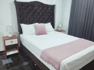 1 dormitorio con 1 cama grande y 2 mesitas de noche en Apart Florencia 2 con cochera!, en Tacna