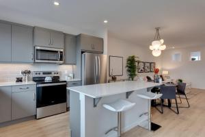 a kitchen with a large white island in a kitchen at Luxurious Modern Home With King Bed & Office in Calgary