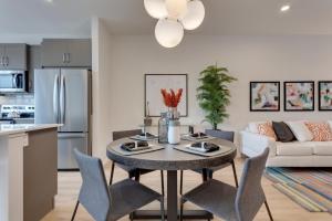 a kitchen and living room with a table and chairs at Luxurious Modern Home With King Bed & Office in Calgary