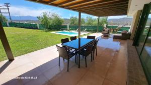 une terrasse avec une table, des chaises et une piscine dans l'établissement Laderas de Chacras vista Montaña en Barrio Privado, à Chacras de Coria