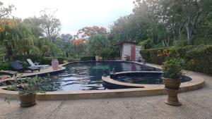 uma piscina num quintal com duas cadeiras e plantas em Beautiful bungalow with a communal outdoor pool and 2 km from the sandy beach em Ban Sa