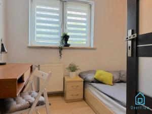 a room with a desk and a bed and a window at Cheerful Room in Gdańsk