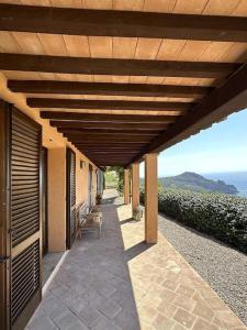 a patio with a wooden pergola with a view at BB24 - Cottage il Puntino in Porto Santo Stefano