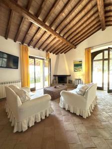 a living room with two white couches and a fireplace at BB24 - Cottage il Puntino in Porto Santo Stefano