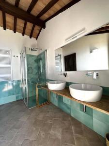 uma casa de banho com 2 lavatórios e uma cabina de duche em vidro. em BB24 - Cottage il Puntino em Porto Santo Stefano