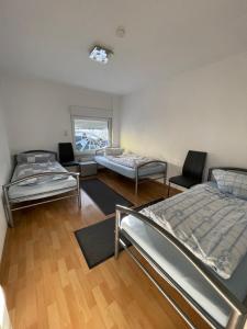 Habitación con 3 camas y mesa. en SoNi Apartment, en Dieburg
