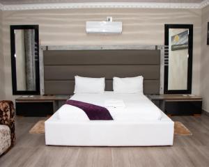 a bedroom with a large white bed and two mirrors at Boeketlong Lodge in Jane Furse +66 photos