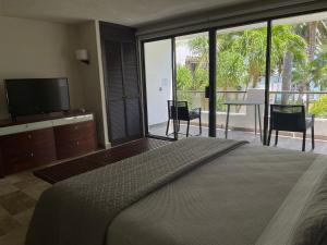 a bedroom with a large bed and a large window at Sina Suites in Cancún