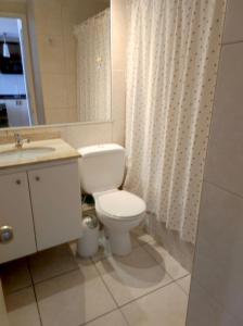 a bathroom with a toilet and a sink and a mirror at VISTAMAR COSTALILENES CONCON in Concón