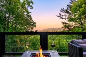 a fire pit on a balcony with glasses of wine at Woodhaven - Private - 3 Suites - Gorgeous Views - 3 Pools - GameRm - HotTub - Lots of Bears in Gatlinburg