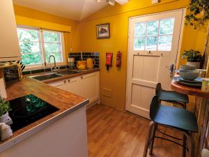a kitchen with yellow walls and wooden floors and a counter at Lytham Hall Gate House in Lytham St Annes +11 photos