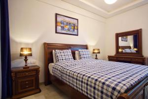 1 dormitorio con 1 cama con manta a cuadros y espejo en Nice Apartment close to Casablanca Airport, en Nouaceur