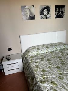 1 dormitorio con 1 cama y cuadros en la pared en LA Tavola Ristorante Pizzeria Da Rino & Figli, en Villaspeciosa
