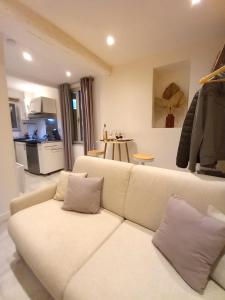 ein Wohnzimmer mit einem weißen Sofa und einer Küche in der Unterkunft #1 Studio # Place charmante in Toulon