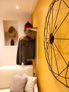 ein Zimmer mit einer gelben Wand mit einer Uhr an der Wand in der Unterkunft #1 Studio # Place charmante in Toulon