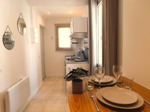 a kitchen with a table with plates and wine glasses at #1 Studio # Place charmante in Toulon
