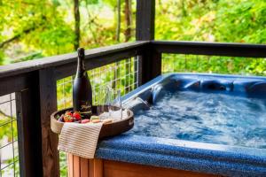 a hot tub on a balcony with a bottle of wine at Woodhaven - Private - 3 Suites - Gorgeous Views - 3 Pools - GameRm - HotTub - Lots of Bears in Gatlinburg