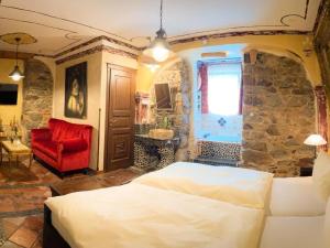 1 dormitorio con 1 cama grande y 1 silla roja en Black Forest Hotel Todtnau, en Todtnau