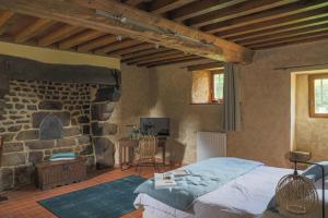 ein Schlafzimmer mit einem Bett und einer Steinwand in der Unterkunft Manoir avec Piscine et Jacuzzi en Suisse Normande in La Carneille