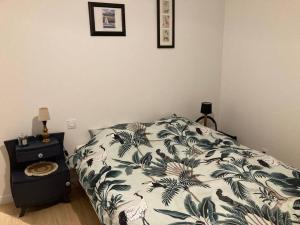 una camera da letto con un letto con un piumone bianco e nero di Gîte Ty Guen à Paimpol a Paimpol