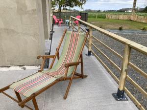 a rocking chair sitting on a porch next to a fence at Gîte Ty Guen à Paimpol in Paimpol