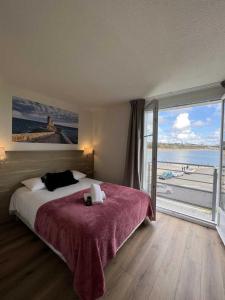 a bedroom with a large bed and a large window at Couett'Hôtel Brest in Brest