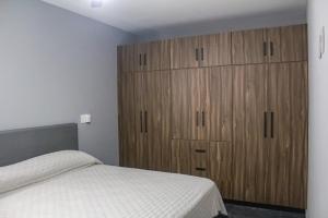 a bedroom with a bed and wooden cabinets at Playa Victoria in Mazatlán