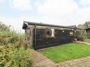 een klein houten huis met een tuin bij Hawthorne Lodge in Skinningrove