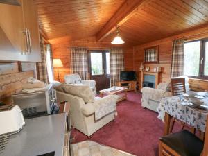 een woonkamer met een bank en stoelen in een hut bij Hawthorne Lodge in Skinningrove