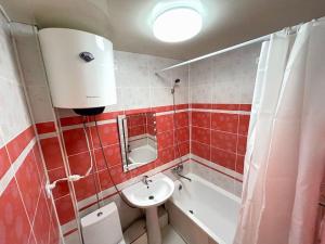 ein Badezimmer mit einem Waschbecken, einem WC und einer Badewanne in der Unterkunft Квартира в самом центре in Qaraghandy