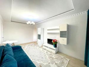 ein Wohnzimmer mit einem blauen Sofa und einem Tisch in der Unterkunft Квартира в самом центре in Qaraghandy