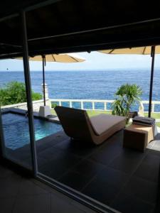 a view of the ocean from a patio with an umbrella at Nusa Lembongan Villa Shambala in Nusa Lembongan