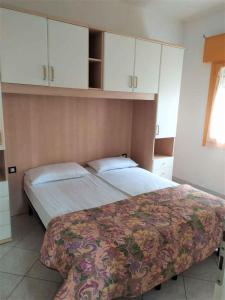 sypialnia z 2 łóżkami i białymi szafkami w obiekcie Apartments in Rosolina Mare 25092 w mieście Rosolina Mare