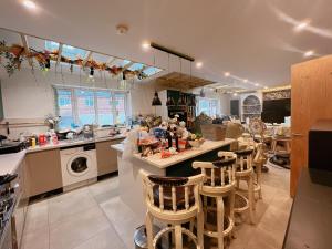 a kitchen with a counter and some chairs in it at Detached house a room in Essex in Waltham Abbey