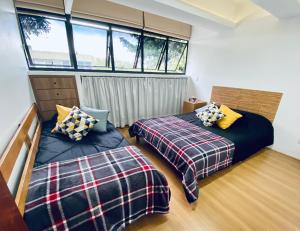 1 dormitorio con 2 camas y ventana en Apartamento amplo a 4km do aeroporto internacional de Guarulhos Cecap, en Guarulhos