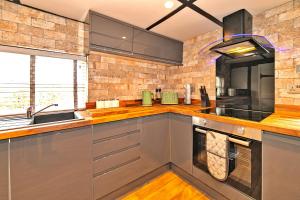 a kitchen with stainless steel cabinets and a sink at Finest Retreats - Roxton Roost in Potton