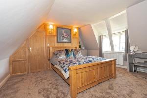 a bedroom with a wooden bed and a desk at Finest Retreats - Roxton Roost in Potton