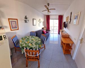 a kitchen and living room with a table and chairs at Eldorado Emily 1 Bedroom Sea view in Playa de las Americas