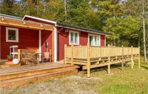 una casa roja con una gran terraza de madera en Pet Friendly Home In Hstveda With Wifi en Hästveda